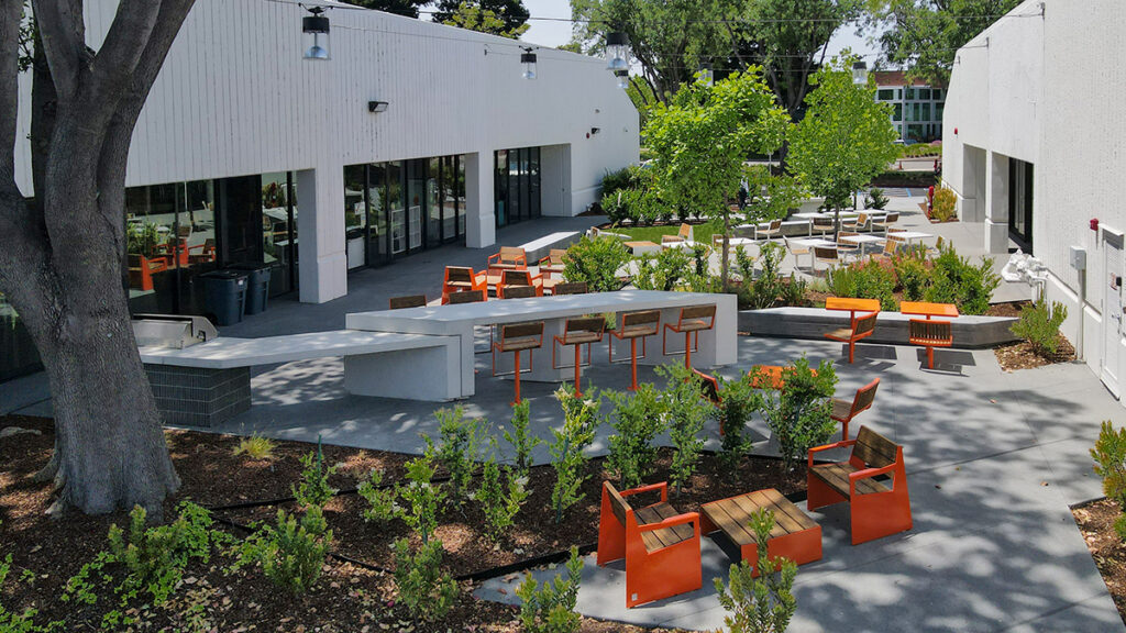 Exterior amenity space at Montague Square with tree-shaded tables and countertops